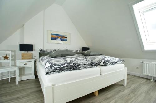 um quarto com uma cama branca e uma janela em Risgap 5 B, App 24 em Wenningstedt