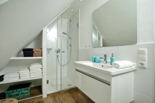 uma casa de banho branca com um lavatório e um chuveiro em Risgap 5 B, App 24 em Wenningstedt