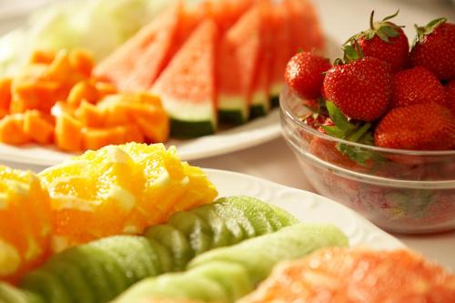 a table topped with plates of fruit and vegetables at Hotel Ochsen Stuttgart in Stuttgart