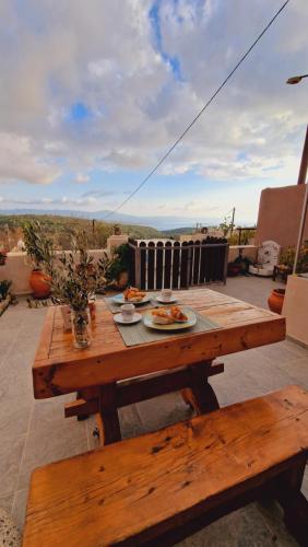einem Holztisch mit einem Teller Essen drauf in der Unterkunft Seva Monolithos house in Monólithos