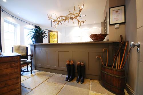 a room with a bar with boots on the floor at Monachyle Mhor Hotel in Lochearnhead