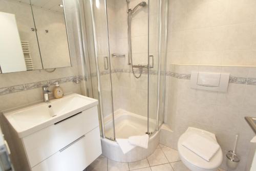 une salle de bains avec douche, toilettes et lavabo dans l'établissement Haus Günther - Mittelweg 1, App 2, à Wenningstedt