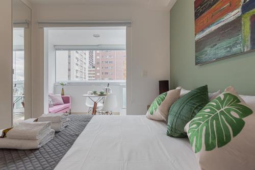 a bedroom with a large white bed with green pillows at Easy Star - Apartamento Encantador ao Lado da Faria Lima - BU01H in Sao Paulo