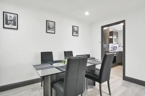 a dining room with a table and black chairs at Long Stay Heaven Penthouse Near Longcross Studios in Brookwood