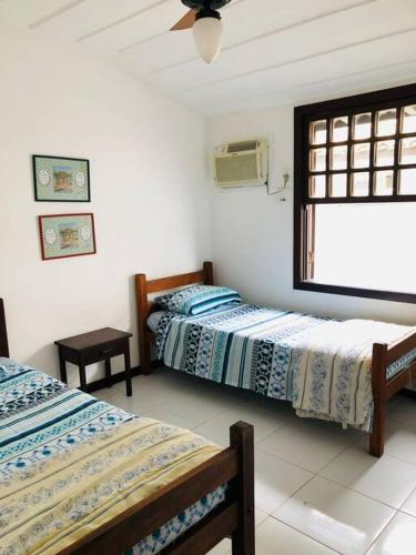 a bedroom with two beds and a window in it at Praia de Geribá C 1 in Búzios