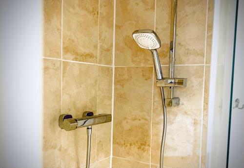 a shower with a shower head in a bathroom at Safari Lodge - Close to Shopping Centre and Restaurants, Free Parking, Stylish and Amazing Artwork in Burton upon Trent