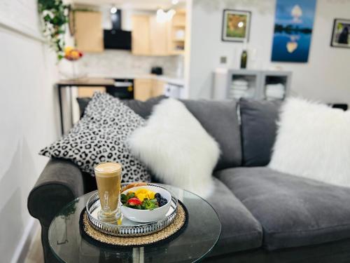 a coffee table with a bowl of fruit and a drink on a couch at Safari Lodge - Close to Shopping Centre and Restaurants, Free Parking, Stylish and Amazing Artwork in Burton upon Trent