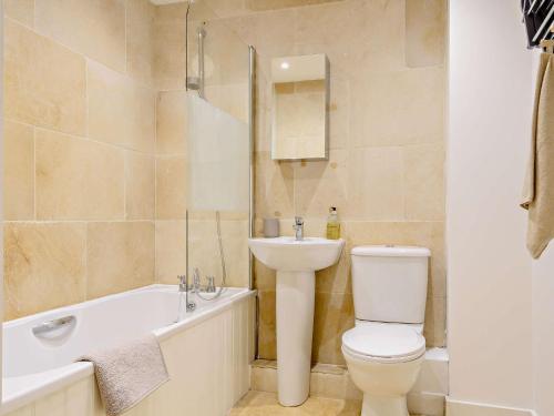 a bathroom with a toilet and a sink and a bath tub at 1 Bed in cotswolds 90128 in Cirencester