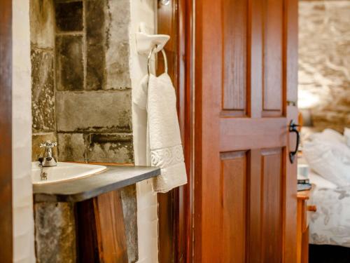 uma casa de banho com um lavatório ao lado de uma porta em 2 Bed in Polperro 90174 em Lansallos