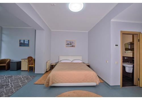 a bedroom with a bed and a bathroom with a sink at Olympic Sport in Podgortsy
