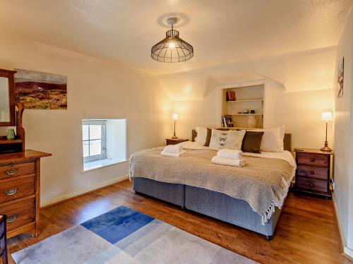 ein Schlafzimmer mit einem Bett, einer Kommode und einem Fenster in der Unterkunft 3 Bed in Hartington 90125 in Hartington