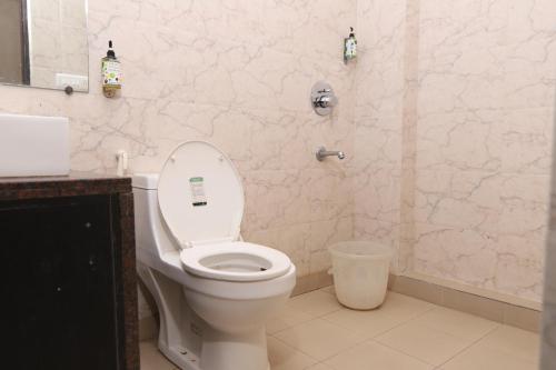 uma casa de banho com um WC branco e um lavatório. em Green View Residency em Greater Noida