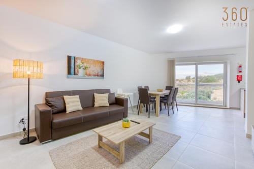 sala de estar con sofá y mesa en Lovely 3BR Apt with Private Balcony & Views in Mgarr by 360 Estates en Mġarr