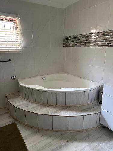 a large bath tub in a white bathroom at 39 HOOG STREET in Polokwane