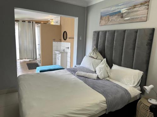 a bedroom with a large bed with a gray headboard at 39 HOOG STREET in Polokwane