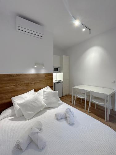 Un dormitorio con una cama con toallas blancas. en SD Habitación céntrica con baño y minicocina, en Terrassa