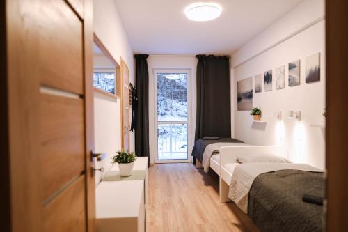 Habitación con 2 camas y ventana en Forest View Apartment, en Jáchymov