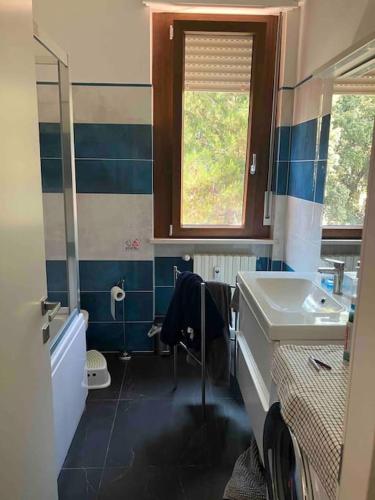 een blauwe en witte badkamer met een wastafel en een spiegel bij Casa Arnold in Ancona
