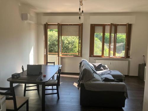 een woonkamer met een bank en een tafel met een laptop bij Casa Arnold in Ancona