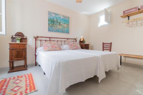 um quarto com uma cama grande e um cobertor branco em Luxury El Patio de la Judería em Córdoba