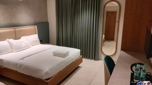 1 dormitorio con cama y espejo grande en Livi Suites - Premium 1 BHK Serviced Apartments en Bangalore