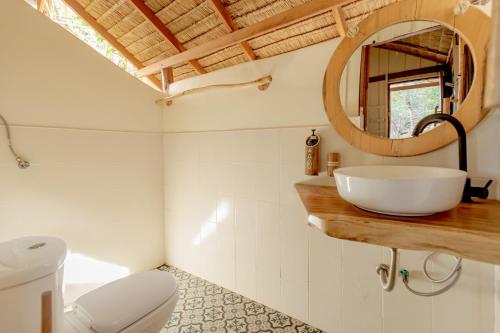 a bathroom with a white sink and a mirror at Why Nam Beach in Haad Yuan
