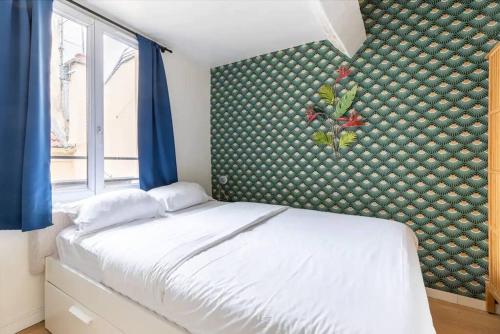 - une chambre avec un lit blanc et un mur avec des rideaux bleus dans l'établissement Grands Boulevards 52 Appartement Cosy 1BR-4P, à Paris