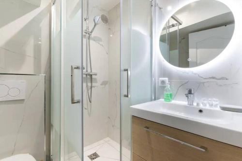 une salle de bain avec une douche, un lavabo et un miroir dans l'établissement Grands Boulevards 52 Appartement Cosy 1BR-4P, à Paris