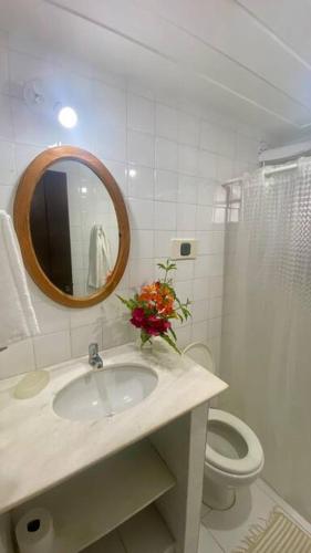 a bathroom with a sink and a toilet and a mirror at Praia de Geribá c2 in Búzios