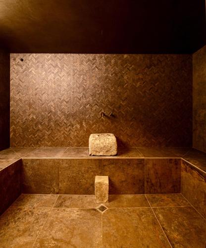 a bath tub with a rock in the middle at Ddò Relais di Puglia in Ostuni