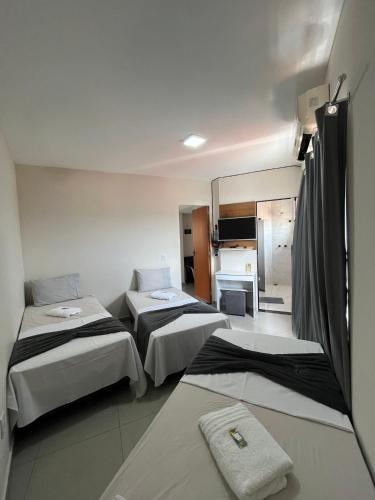 a hotel room with three beds and a mirror at Casa Lua in Brumadinho