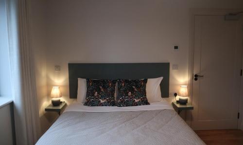 - une chambre avec un grand lit et deux lampes dans l'établissement Cedar Lodge, à Killarney