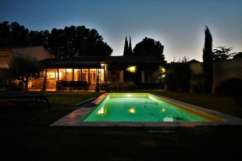 a swimming pool in front of a house at night at Le Chat Sur Le Toit in Lourmarin