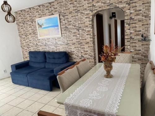 uma sala de estar com um sofá azul e uma mesa em Apartamento na orla de Olinda em Olinda