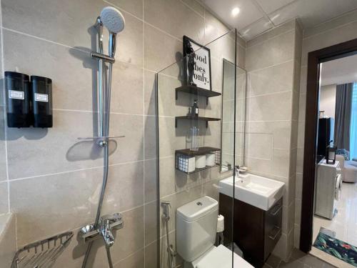 a bathroom with a shower and a toilet and a sink at Ashri HH Bright Apt-Damac hills2 in Dubai