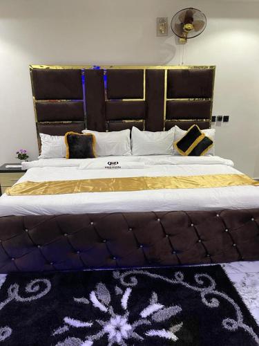 a bedroom with a large bed with a large headboard at Hilton Garden Inn Ltd in Nsukka