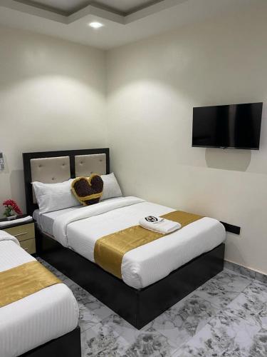 a bedroom with two beds and a flat screen tv at Hilton Garden Inn Ltd in Nsukka