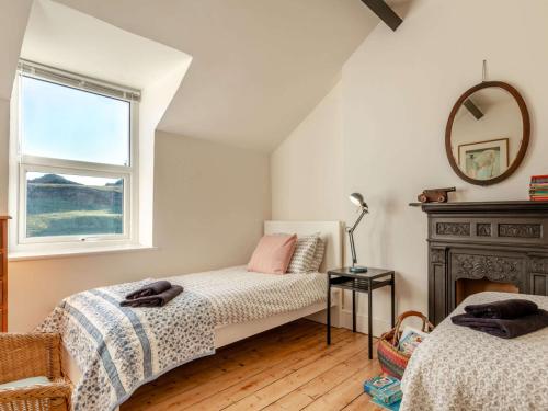 two beds in a room with a mirror and a window at 4 Bed in Woolacombe 90224 in Mortehoe