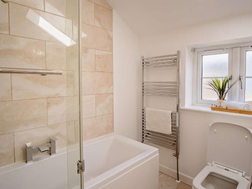 a white bathroom with a tub and a toilet at 3 Bed in Newport 90250 in Newport