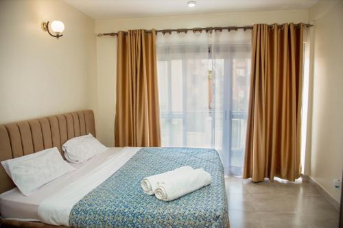 1 dormitorio con 1 cama con 2 toallas en FG Homestay, Kampala Muyenga-Bukasa, en Kampala