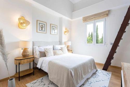 a white bedroom with a bed and a window at Sunny Home in Benalmádena