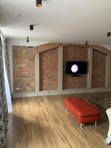 a living room with a brick wall and a tv at Apartament Gold 2 in Złotoryja