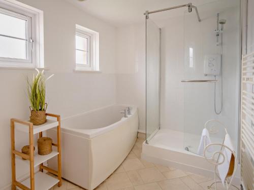 2 Bed in Newport 90247 في نيوبورت: حمام أبيض مع حوض استحمام ودش