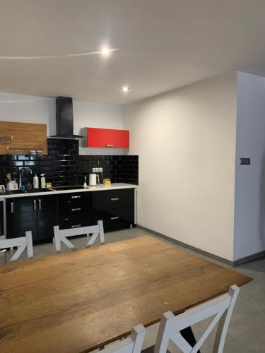 a kitchen with black and white counters and white chairs at Apartament Gold 2 in Złotoryja