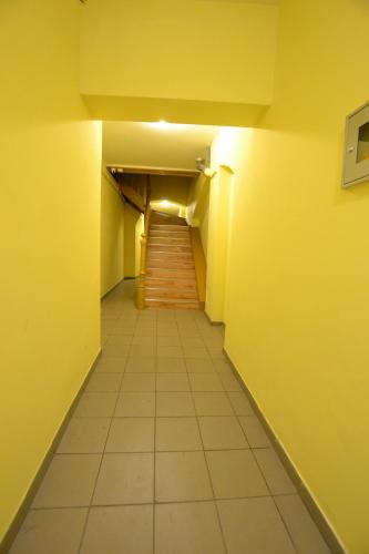 a long hallway with yellow walls and a staircase at Apartament Gold 2 in Złotoryja