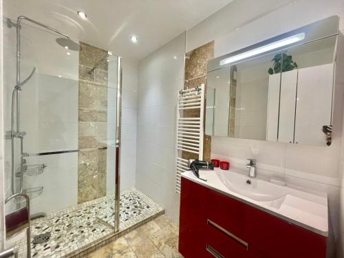 La salle de bains est pourvue d'un lavabo rouge et d'une douche. dans l'établissement Studio Grand hôtel Croisette, by Welcome to Cannes, à Cannes