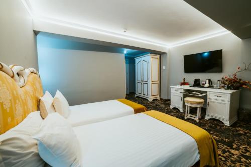 a hotel room with two beds and a desk at SunGarden Golf & Spa Resort in Cluj-Napoca