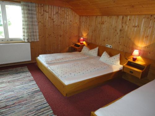 1 dormitorio con 1 cama grande y 2 lámparas en Haus Mellenbach, en Mellau
