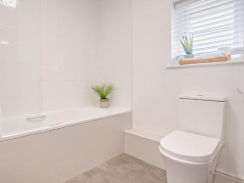 bagno bianco con servizi igienici e finestra di 2 Bed in Newport 90243 a Newport