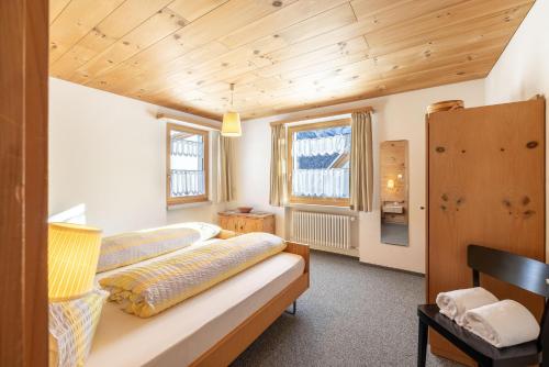 um quarto com uma cama e um tecto de madeira em Chasa Val Parterre em Scuol